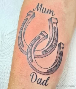 Фото тату трех подков с надписями 'Mum' и 'Dad' в черно-серых тонах. Сентиментальный и трогательный рисунок татуировки на руке.