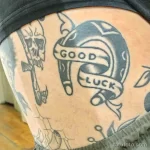 Фото тату подковы в стиле олд скул с надписью 'Good Luck' на руке. Черно-серый рисунок татуировки с четкими контурами и традиционным дизайном.