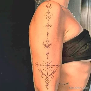 Черно-белая татуировка на плече и руке, выполненная в технике dotwork с изображением геометрических фигур и луны.