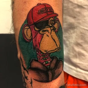 Фото тату обезьяны из коллекции Bored Ape Yacht Club на руке, выполненной в ярких цветах с высокой детализацией и реалистичными тенями.