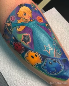 Фото тату принцессы Пич из Super Mario на ноге. Яркие цвета, мультяшный стиль, детализированный рисунок татуировки.