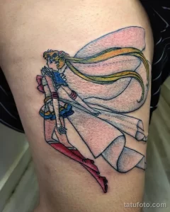 Фото татуировки Sailor Moon на ноге, выполненной в ярких цветах с использованием аниме-стиля и детализированной проработкой.
