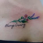 Фото татуировки: небольшая ветка с цветами и надписью 'Always Growing' на теле. Минималистичный и вдохновляющий рисунок татуировки.