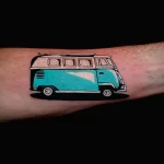 Фото татуировки в виде старинного фургона на предплечье. Черно-белый рисунок, ретро-стиль.
