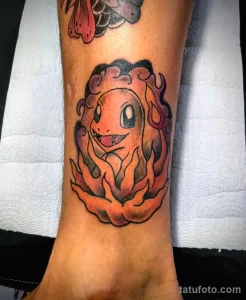 Фото тату: красочный рисунок покемона Charmander, выполненный на руке в стиле аниме.