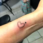 Фото маленькой татуировки в виде сердца, выполненного точками (dotwork) на предплечье. Минималистичный дизайн, нежный и женственный.