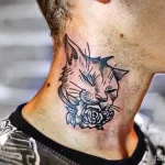 Фото тату: портрет кота с розовыми бутонами, выполненный в стиле олдскул на шее мужчины. Цветная татуировка с четкими контурами и яркими красками.