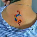 Красочная татуировка змеи, выполненная в радужных цветах. Оригинальный рисунок татуировки, привлекающий внимание своей яркостью и необычностью.