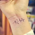 Фото тату на запястье, изображающее линию пульса с инициалами 'R'. Черно-белый рисунок, минималистичный дизайн, персонализированный эскиз.
