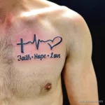 Фото тату на груди, изображающее пульс, крест и надпись 'Faith Hope Love'. Черно-белый рисунок, религиозная тематика.