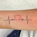 Фото татуировки: линия пульса сердца с надписью 'love life'. Символичное изображение любви к жизни и позитивного настроя.