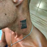Фото тату штрихкода на шее мужчины. Черный рисунок татуировки с цифровым кодом и датой, расположенный сбоку шеи.