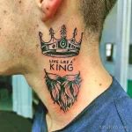 Фотография татуировки короны над бородой с надписью "Live Like a King" на шее мужчины. Черно-белый рисунок татуировки с детальной проработкой.