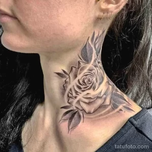 Фото тату: Черно-белая татуировка розы на шее, выполненная в технике blackwork. Изящный и стильный рисунок татуировки.