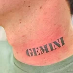 Фото тату надписи 'Gemini' на шее в стиле Old School. Яркие цвета, жирные линии, классический стиль. Подходит для тех, кто гордится своим знаком зодиака.