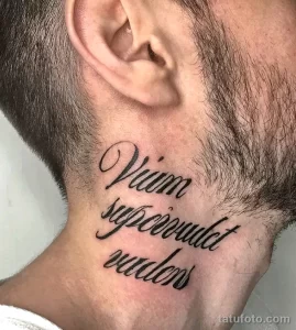 Фото тату латинской фразы 'Vitam Sepcoundet Audens' на шее. Черный контур, каллиграфический шрифт, элегантный стиль. Подходит для тех, кто ценит мудрость и смелость.