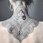 Фотография изысканной татуировки в стиле дотворк на задней части шеи женщины, выполненной черными чернилами.