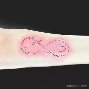 Фото тату на руке: надпись "Angels in my heart" и изображение сердца, выполненные в розовых тонах. Памятная татуировка для девушек.