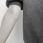 Фото тату на ноге: минималистичный рисунок сердца, выполненный тонкой линией. Простой и элегантный дизайн.