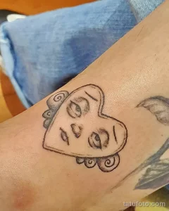 Фото тату Губки Боба на предплечье. Черно-белый рисунок татуировки с изображением головы Губки Боба, выполненный в мультяшном стиле.