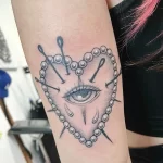 Фото тату: черно-белая татуировка в стиле blackwork на руке. Изображено сердце, пронзенное булавками, с каплями слез.