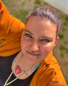 Фото тату сердца, расположенного на фоне лица. Оригинальный и смелый дизайн татуировки, привлекающий внимание.