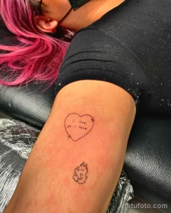 Фото татуировки на руке: небольшая надпись "I live so I love" и изображение пламени, выполненные тонкими линиями. Идеи для минималистичных тату с цитатами.