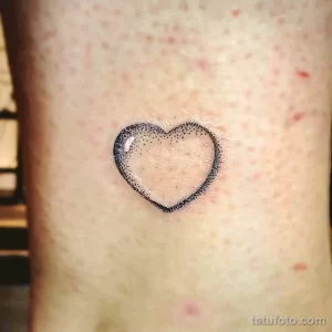 Фото тату: сердце, выполненное в технике dotwork, с использованием множества точек. Деликатный и изящный рисунок татуировки на коже.