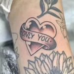 Фото тату сердца с надписью 'ONLY YOU' и розой, выполненное в черно-серых тонах с добавлением акварельных эффектов.