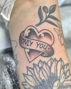 Фото тату сердца с надписью 'ONLY YOU' и розой, выполненное в черно-серых тонах с добавлением акварельных эффектов.