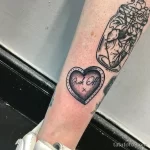 Фото тату сердца с надписью 'Fuck Off' на ноге. Черно-белый рисунок, грубый стиль, провокационная надпись, символ протеста и независимости.
