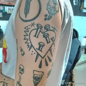 Фото тату в стиле doodle на руке. Изображены сердце, очки, коктейль и другие элементы, выполненные в виде наброска.