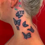 Фото тату на шее: несколько бабочек, летящих вверх, с добавлением чисел "777". Оригинальный и мистический рисунок татуировки.