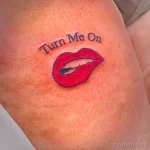 Фото тату с изображением красных губ и надписи "Turn Me On". Яркий и сексуальный рисунок.