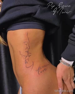 Фото тату: минималистичная татуировка в стиле line art, изображающая два профиля лиц и надпись "Do all things with love" на боку.