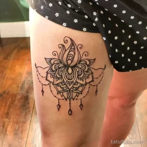 Фото тату на бедре: сложная мандала, выполненная в стиле blackwork, с геометрическими узорами и тонкими линиями.