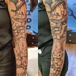 Фото тату на руке с изображением персонажей Looney Tunes, денег и игральных костей. Яркий и детализированный рисунок в мультяшном стиле.