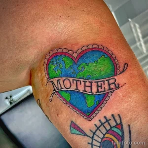 Фото тату: Земля, заключенная в сердце, с надписью 'Mother'. Яркий и символичный эскиз тату для выражения любви к матери и планете.