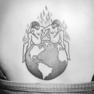 Фото тату на груди: черно-белая графическая татуировка с изображением Земли, двух человеческих фигур и языков пламени.