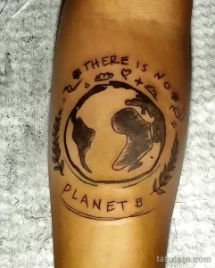 Фото тату на руке с изображением Земли и надписью 'There is no Planet B'. Рисунок выполнен в минималистичном стиле.