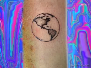 Фото тату минималистичного рисунка Земли на руке. Черный контур, простой дизайн, идея для небольшого тату.