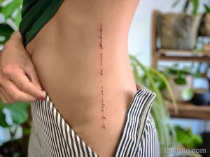 Фото тату с надписью на боку. Черно-белый рисунок татуировки, каллиграфический эскиз тату, цитата на иностранном языке.