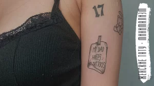 Фото тату с числом '17' и надписью 'My Dad Hates Tattoos' на руке. Простой черно-белый рисунок татуировки, минималистичный эскиз тату.