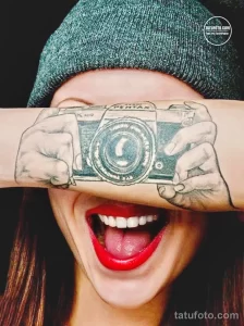 Фото тату на руке: реалистичное изображение старинного фотоаппарата Pentax, выполненное в черно-серых тонах с детальной проработкой.