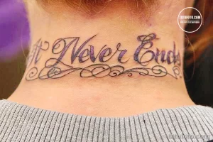 Фото тату: цветная татуировка с надписью "Never End" на шее девушки. Надпись выполнена каллиграфическим шрифтом и украшена узорами.