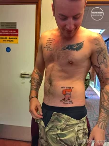 Фото тату на теле: изображение Гомера Симпсона и надпись "Not sure if tattoo or transfer", выполненные в ярком и забавном стиле.