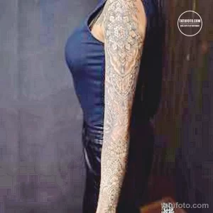 Фото татуировки в виде рукава на женской руке, с изображением цветов, узоров и геометрических фигур. Детализированный и красочный рисунок.