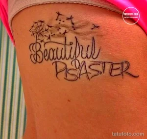 Фото тату надписи 'Beautiful Disaster' на теле, выполненного в каллиграфическом стиле с добавлением звезд. Эскиз татуировки символизирует противоречивую натуру и принятие себя.