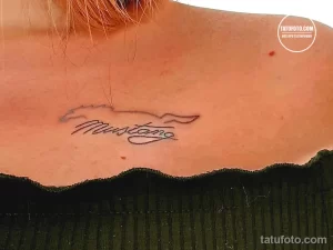 Фото минималистичной татуировки надписи 'Mustang' с изображением лошади, выполненной тонкими линиями.