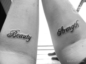 Фото тату: Парные татуировки с надписями "Beauty" и "Strength", выполненные каллиграфическим шрифтом на руках. Минималистичный рисунок татуировки.
